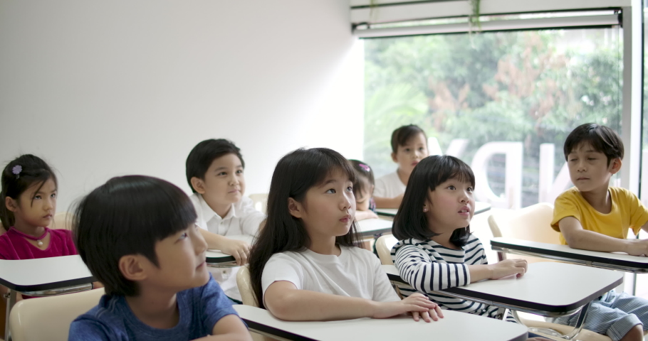 Group of joyful asian elementary students raising their arms to answer a question from teacher at classroom. Kindergarten pre school concept.
 | Shutterstock HD Video #1034176664