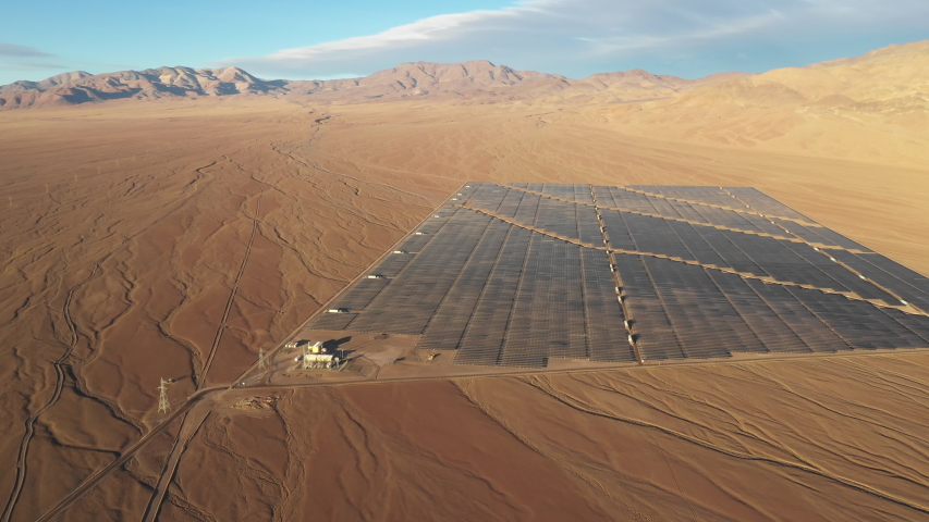 Aerial footage Solar Energy Farm at Atacama Desert, Chile. Thousands solar modules rows passed along Solar Energy PV Plant, awe scenery from an aerial drone point of view in an infinity arid landscape