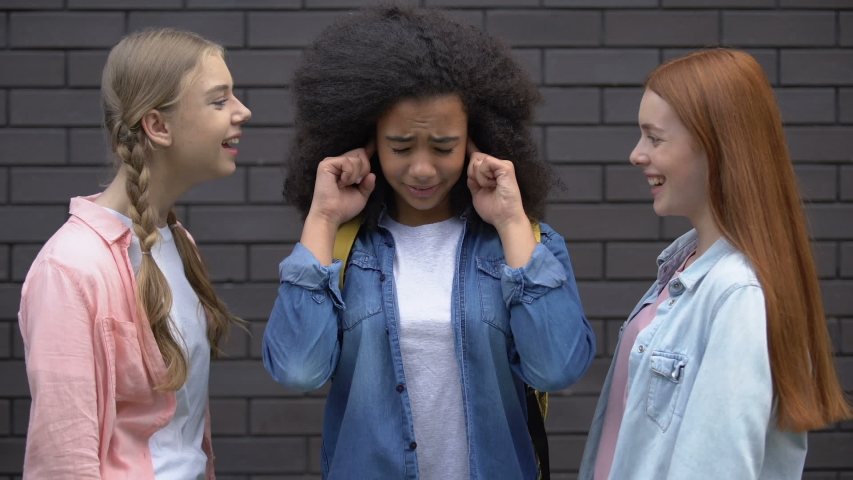 Young females mocking black classmate, bullying victim closing ears, conflict Royalty-Free Stock Footage #1034177828