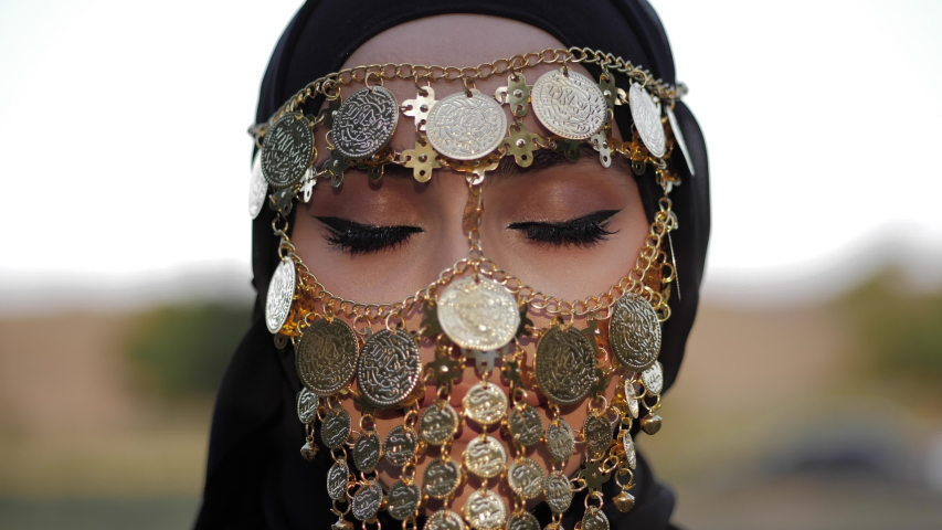 arabian woman with professional makeup in tribal face veil opens eyes and looks at camera close view slow motion Royalty-Free Stock Footage #1034183306