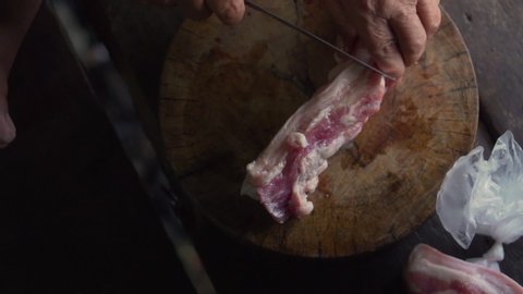 Streaky pork get chopped by old lady hands.