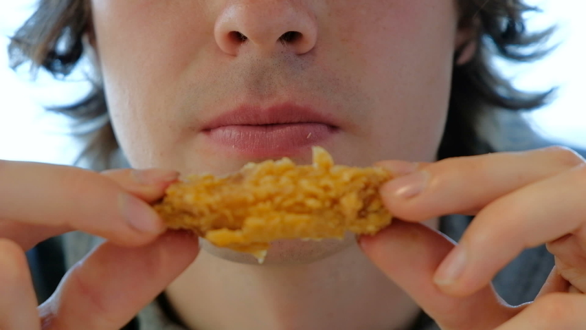 fastfood cafe customer eats spicy chicken slice closeup