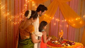 Indian nuclear family worshiping Indian Spiritual Master Sai Baba during festivities. HD stock video of Indian family following Hindu customs and traditions during festivities - Offering prayers. G...