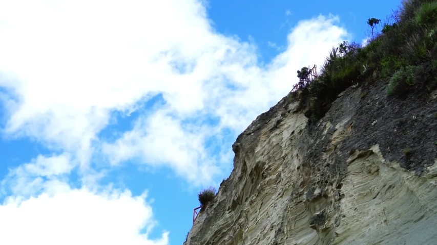 A windy day with clouds rushing past the cliff top