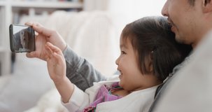 asian father and child using smartphone having video chat little girl waving sharing weekend with with dad enjoying chatting on mobile phone to friend 4k