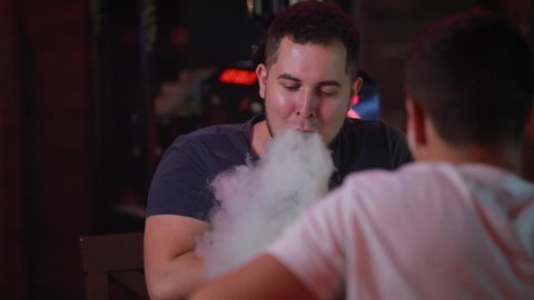 Man friends smoking hookah at bar counter