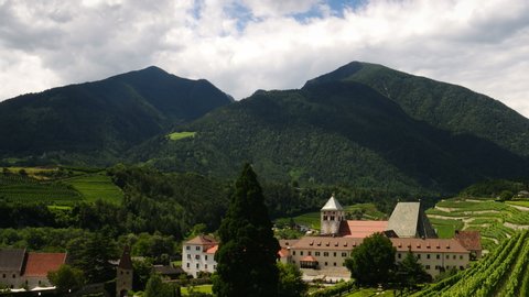 Spectacular view of Novacella Monastery surrounded by green wineyards in South Tyrol. Bressanone, Italy. Timelapse.