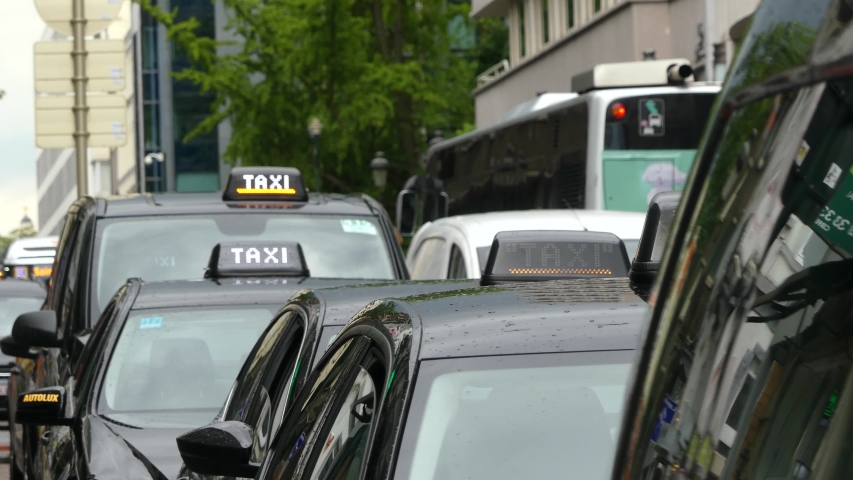 BRUSSELS, BELGIUM - MAY 2019: Taxi sign on the roof of the car. Close-up. Taxi on the background of public transport. Taxi checker.
