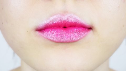 Extreme close-up of young woman's lips. A woman is licking a big lollipop. Femalebright make-up for lips