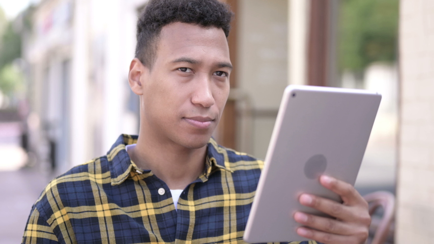 Man Cheering for Success on Tablet Outdoor