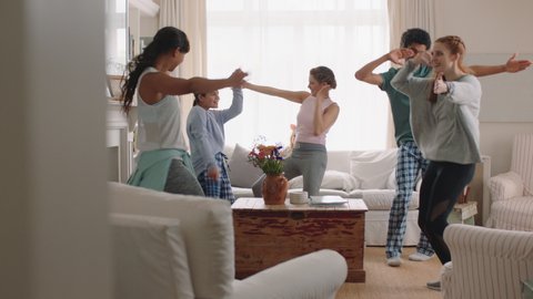 happy multiracial family dancing at home having fun enjoying dance celebrating exciting weekend together wearing pajamas