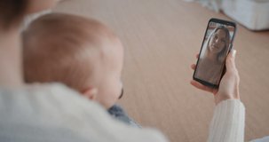 mother and baby using smartphone having video chat with best friend waving at toddler happy mom enjoying sharing motherhood lifestyle on mobile phone screen 4k