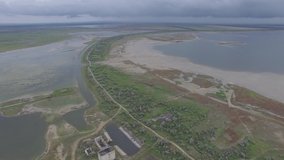 Aerial video of wind turbines on the shores of lakes in cloudy day near Sea of Azov, Crimea. Wind Farm, renewable energy.