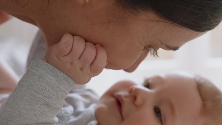 Close up mother gently kissing baby enjoying loving mom playfully caring for toddler at home sharing connection with her newborn child healthy childcare | Shutterstock HD Video #1034236241