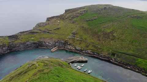 Drone footage looking down on Boscastle harbor with its picturesque fishing village located in a valley in North Cornwall, England