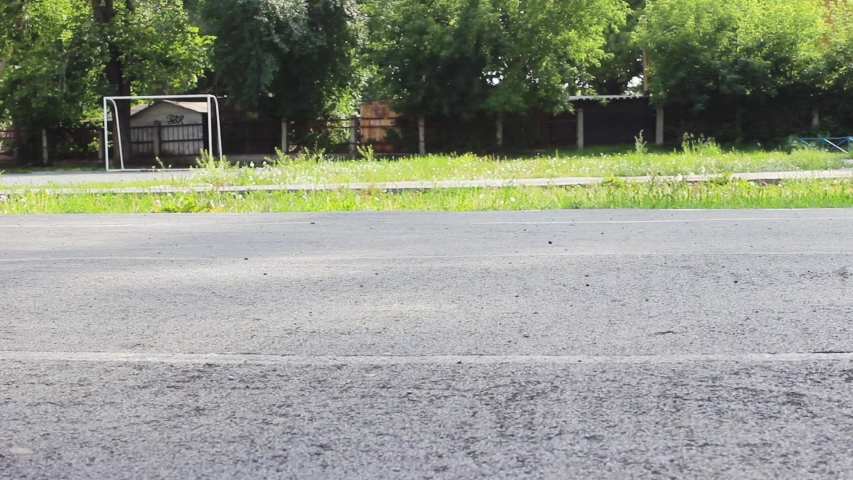 Feet in sneakers are on the street on the Playground.