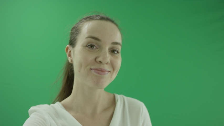 surprised excited woman is laughing. She wears formal dress: white shirt and blak skirt. Lady stands in close up front in the centre of a green screen