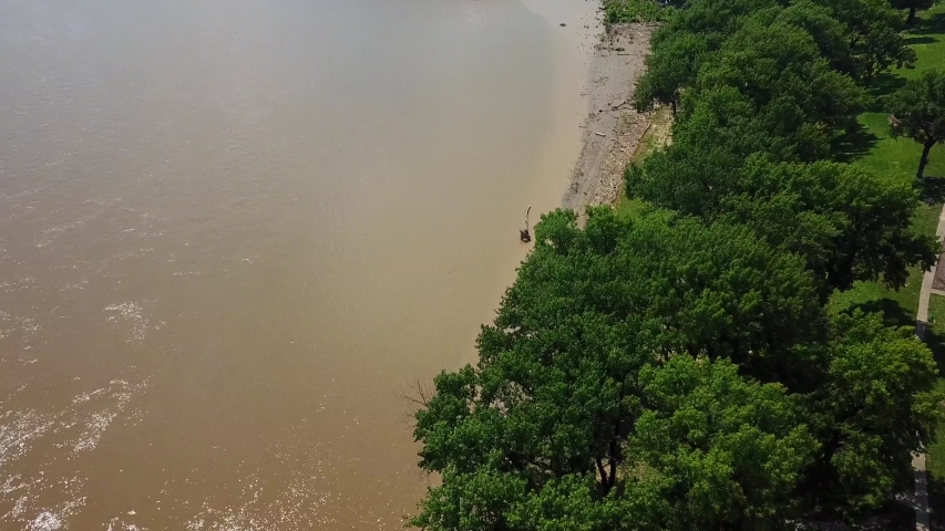 Aerial, tilt up, drone shot, over the Ohio river, revealing a bridge to Louisville, on a sunny, summer day, in Kentucky, USA