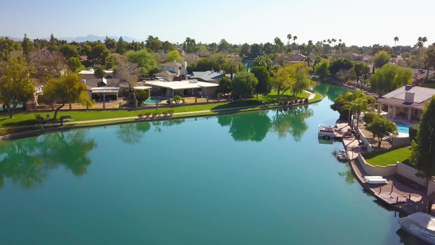 aerial view flying across a lake with desert homes in Arizona