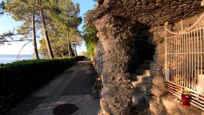 Slow left side movement on a small walkway path next to sea