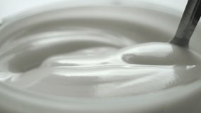 macro - video shooting,Slow motion of mixing yogurt with spoon in the cup
