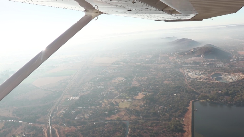 Wide Shot From Passenger Seat of Plane; View of Wing Overlooking Mountains and Morning Landscape