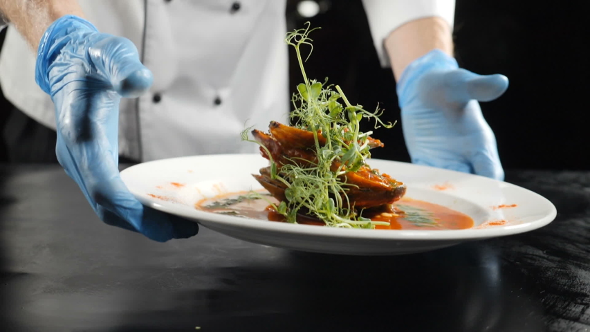 Slow motion food video concept. Chef hands in gloves put white plate with delicious seafood dish in luxury restaurant. Food preparation footage. hd | Shutterstock HD Video #1034274749
