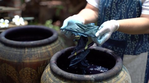 Making northern Thai blue dye fabric cloth textiles with boiling indigo leaf plant