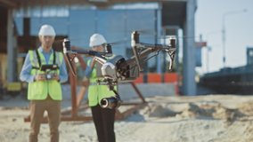 Two Specialists Controlling Drone on Construction Site. Architectural Engineer and Safety Engineering Inspector Fly Drone on Building Construction Site Controlling Quality. Focus on Drone - Powered by Shutterstock - Get 15% off with code: PIKWIZARD15