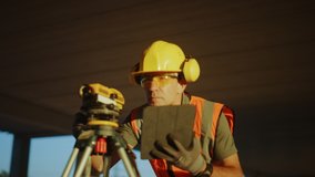 Inside of the Commercial  Industrial Building Construction Site: Professional Engineer Surveyor Takes Measures with Theodolite, Using Digital Tablet Computer - Powered by Shutterstock - Get 15% off with code: PIKWIZARD15