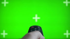 Green Mock-up Screen TV. Male hand holding the TV remote control smart television Internet TV. Searching TV Program
