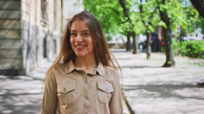 Beautiful elegant woman in fashion look walking in the street. Follow passionate caucasiona girl smiling flirting staying in gorgeous old city.