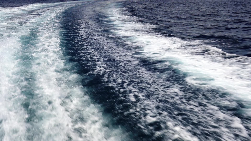 Waves of the sea foam and shallow ripples near the ship.