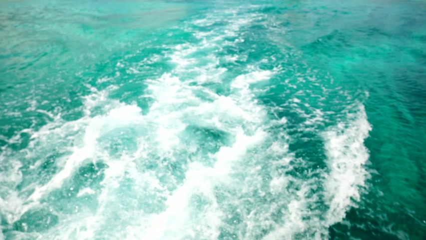 Waves of the sea foam and shallow ripples near the ship.