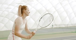 CU HANDHELD Young Caucasian female tennis player hitting a ball during game or practice. 4K UHD RAW graded footage