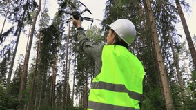 Woman Worker with Drone before take off in forest.Video forest inspection