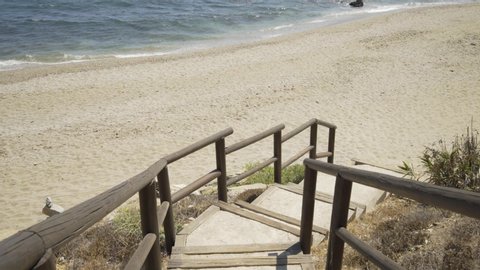 Coming down the steps and onto the sand at the lovely beach of Cala de Mijas on the Costa Del Sol in Southern Spain.