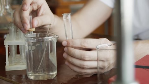 Scientist working with chemical reaction in chemistry lab. Chemical reaction in glass flask. Lab student doing chemical experiment in laboratory