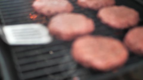 Lid opening on grill and spatula flipping alternative meat (Beyond Meat) burger patties on a barbecue, close up shot with flame in 60 frames per second 4k.