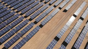 Aerial footage hundreds solar energy modules or panels rows along the dry arid lands at Atacama Desert, Chile. Huge Photovoltaic PV Plant in the middle of the desert from an aerial drone point of view