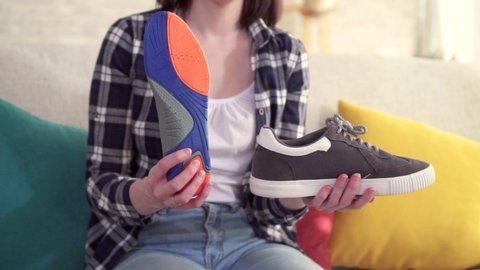 young woman inserts an orthopedic insole into the shoe close up