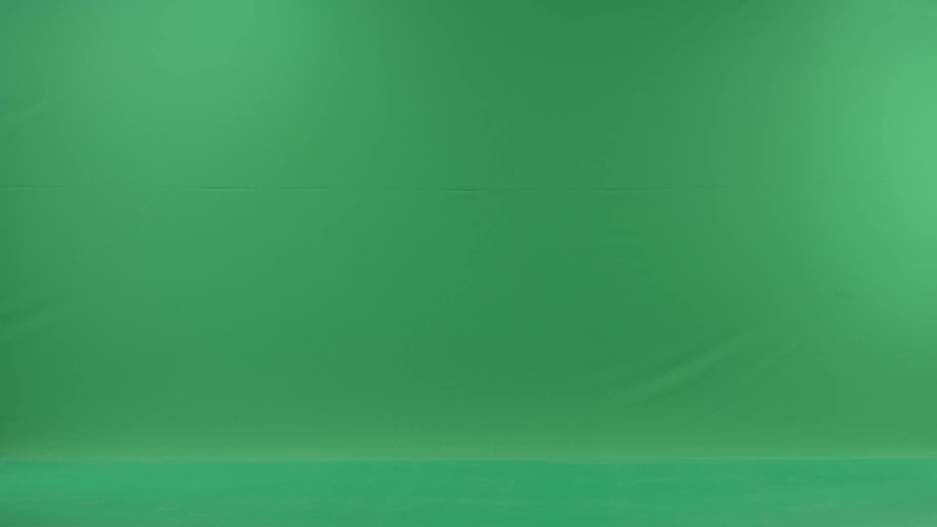 business woman is talking on her mobile cell phone and walking with folders. Lady drops her folders. She wears formal dress: white shirt and blak trousers. Businesswoman is over green screen