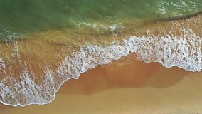 Aerial view of ocean waves crashing on beach by 4K drone footage. Summer seascape from air.