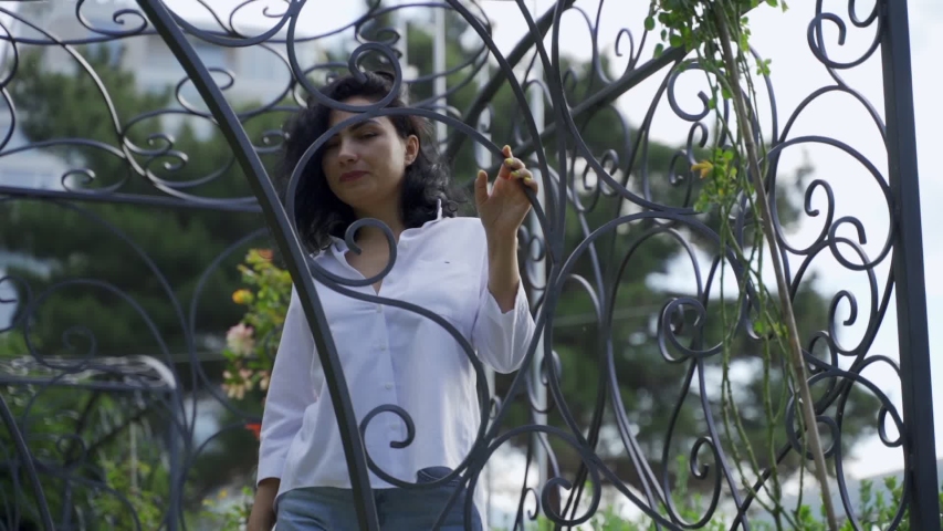 Beautiful Tatar girl stands near the metal gazebo