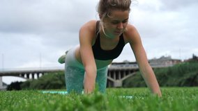 young slim beautiful healthy hipster female outdoors doing sport activity exercise. fit attractive female doing push ups. healthy person during workout. healthy lifestyle and well-being video