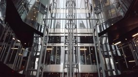 A glass elevator on the side of a modern shopping mall in central London