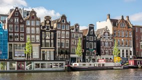 Leaning houses along the Damrak canal waterfront in Amsterdam, Netherlands. Time lapse video.