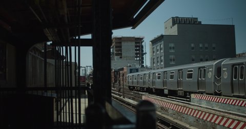 Standing on platform in Williamsburg Brooklyn as New York City subway train pulls out towards Manhattan. : film stockowy