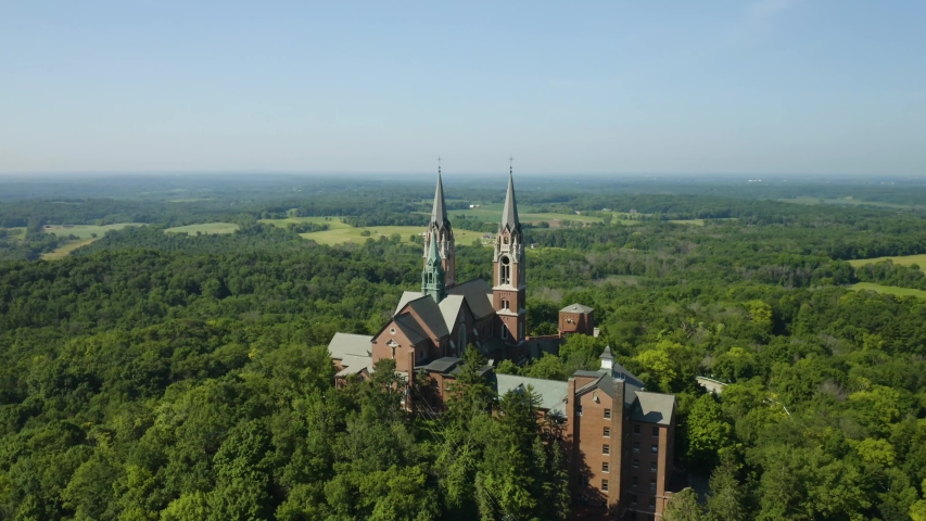 Holy Hill National Shrine of Mary, Wisconsin, USA, aerial view forward flight over Basilica through spires drone footage.