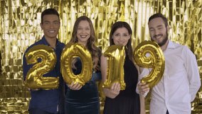 2020 changes 2019. 4 people with golden letters made of foil change the number on a gold background. 4K